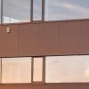 Die Außensirene von Loxone an der Fassade eines modernen Gebäudes bei Sonnenuntergang montiert