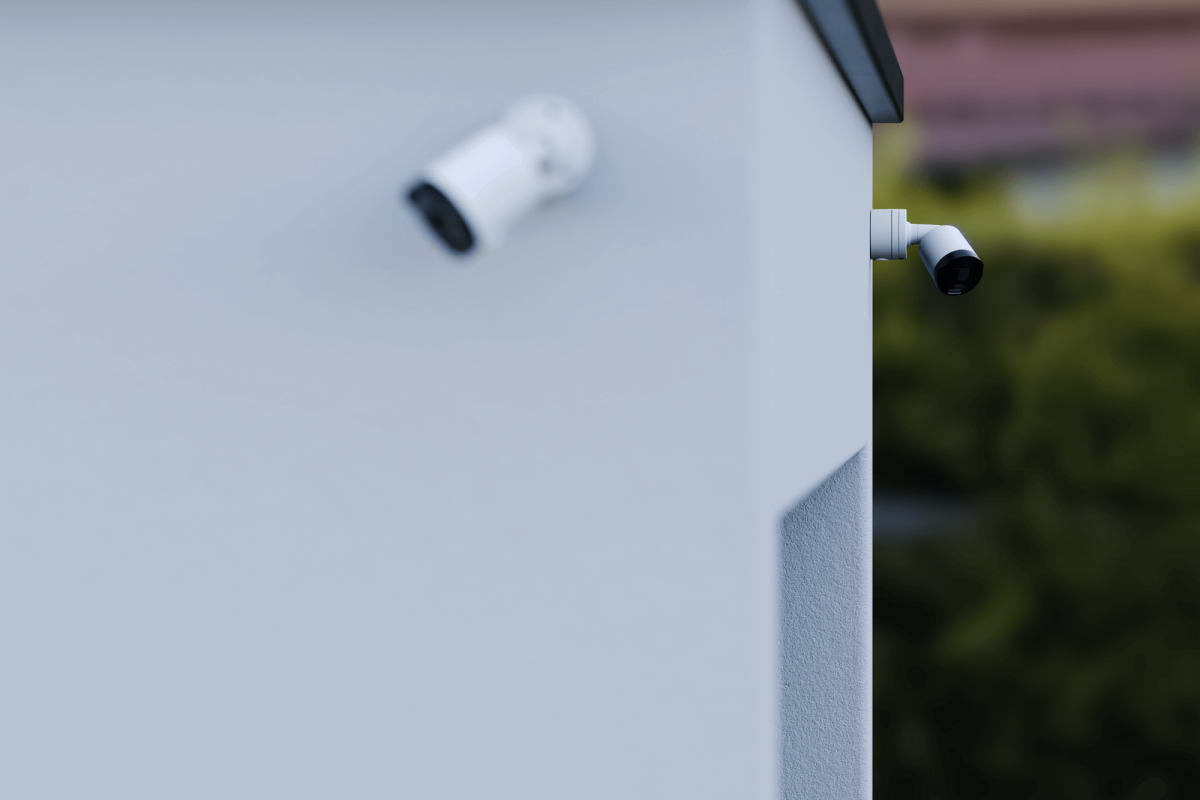 Überwachungskameras an der Wand eines Gebäudes, die auf unterschiedliche Richtungen gerichtet sind.